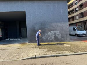 Uso de máquina de agua a presión para eliminar restos de grafiti en una fachada de piedra.