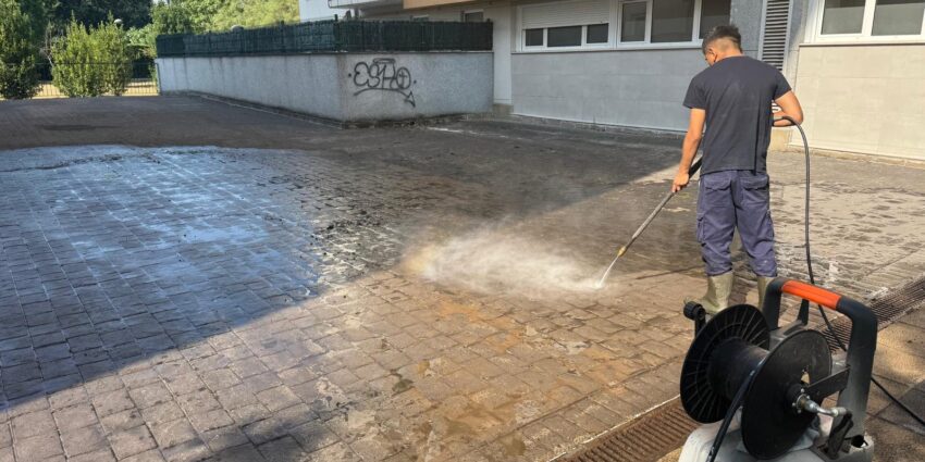 Trabajador realizando una limpieza con hidrolimpiadora en una plaza exterior
